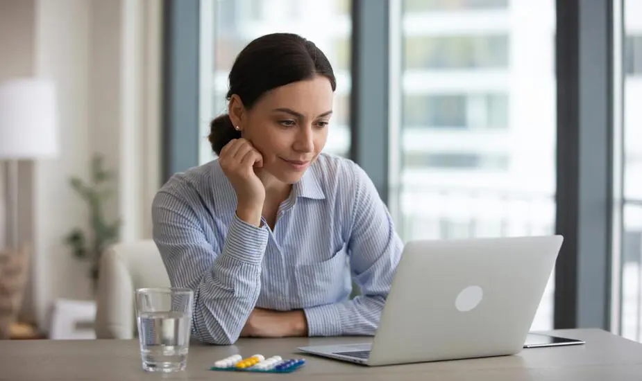 Woman reviewing ADHD and weight-loss medication at a modern desk in a bright London flat